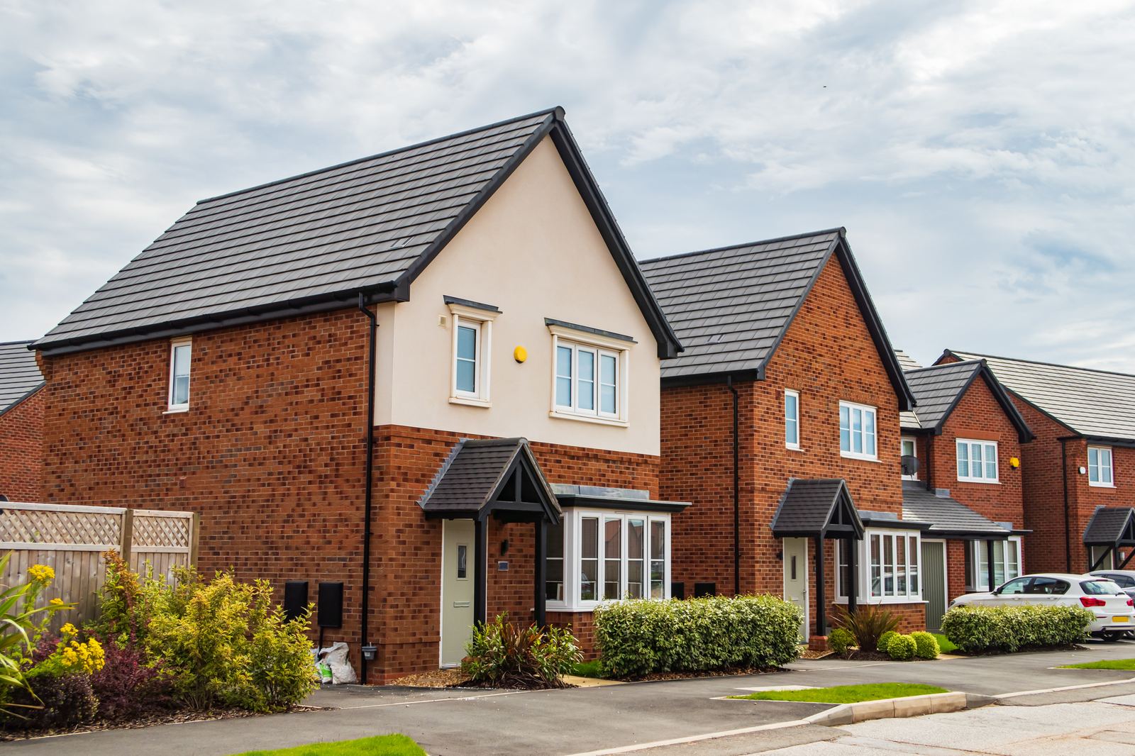 Street of new-build homes with fresh tiled roofs